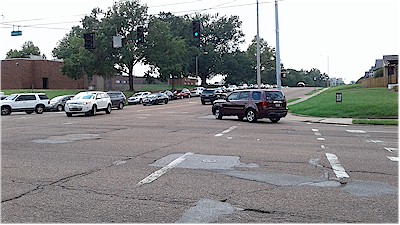 Cars line up from Holmes St. around the corner westward over the hill on Walnut Grove Rd.